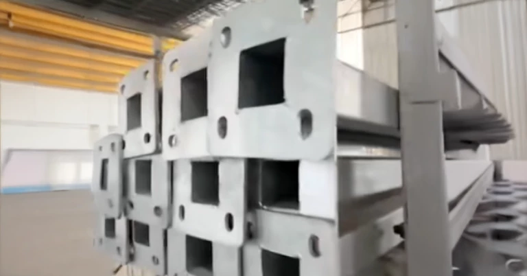 เสาเหลี่ยมเคลือบ hot-dip galvanized วางซ้อนกันเป็นชั้นๆ บนชั้นวางของ